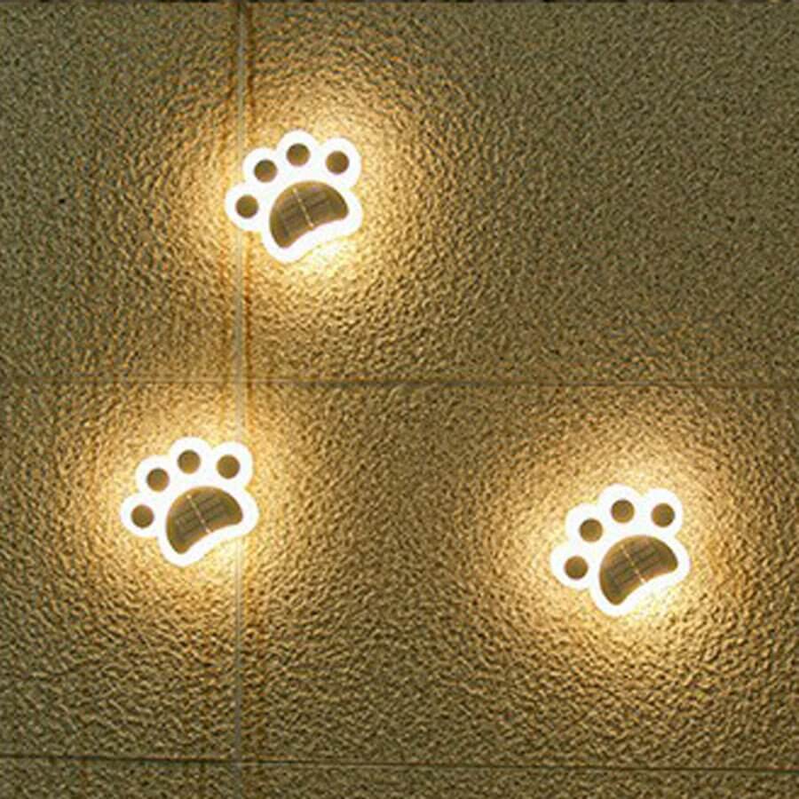 Animal paw step stairs light enhancing a garden pathway with a gentle glow.