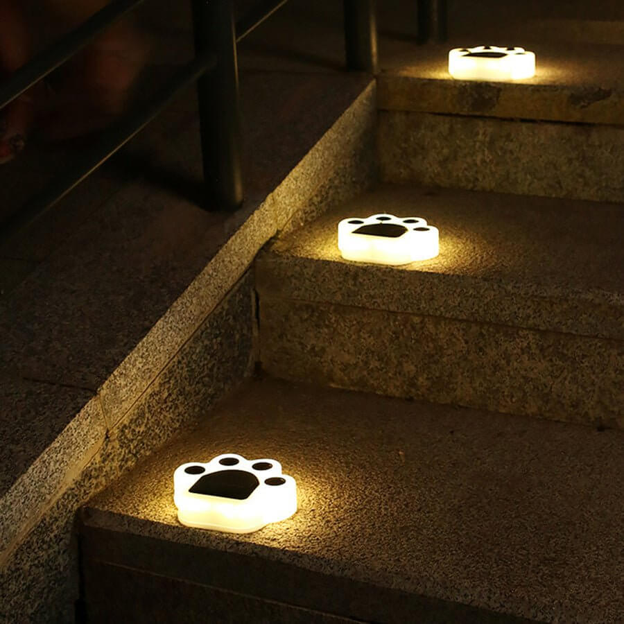 Animal paw step stairs light illuminating outdoor stone steps with a warm glow.