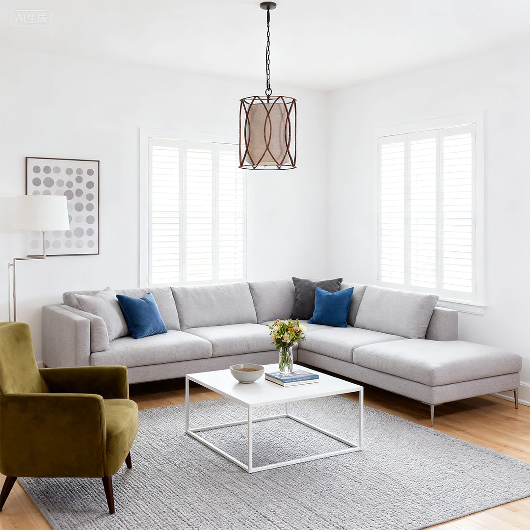 Small black pendant light with an antique bronze finish and cylindrical cloth shade hanging over a modern sectional sofa in a living room.
