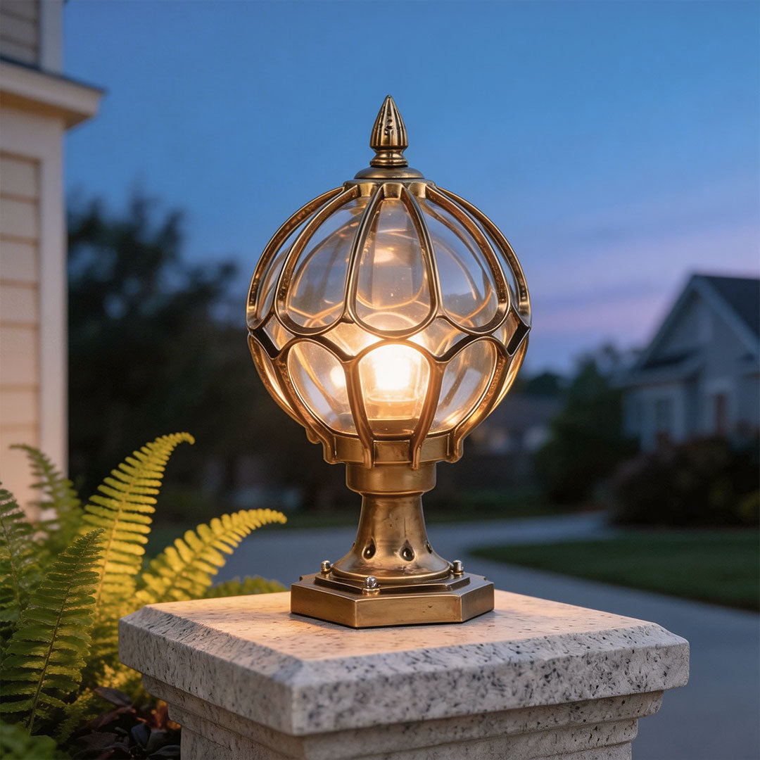 Antique bronze outdoor globe pillar light on a granite post in a suburban garden at dusk ok!!