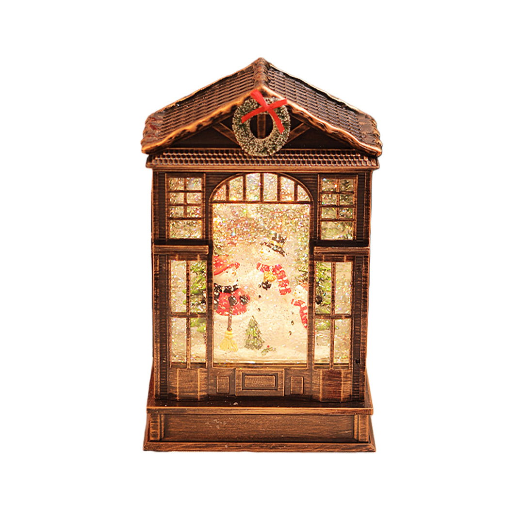 Classic bronze christmas decoration with light showcasing a detailed holiday scene behind frosted glass panels.