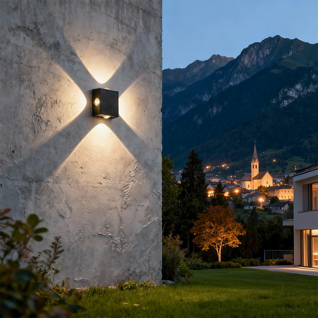 Architectural black outdoor sconce light featuring glass shade chandelier styling creating four-way light spread on stone wall.