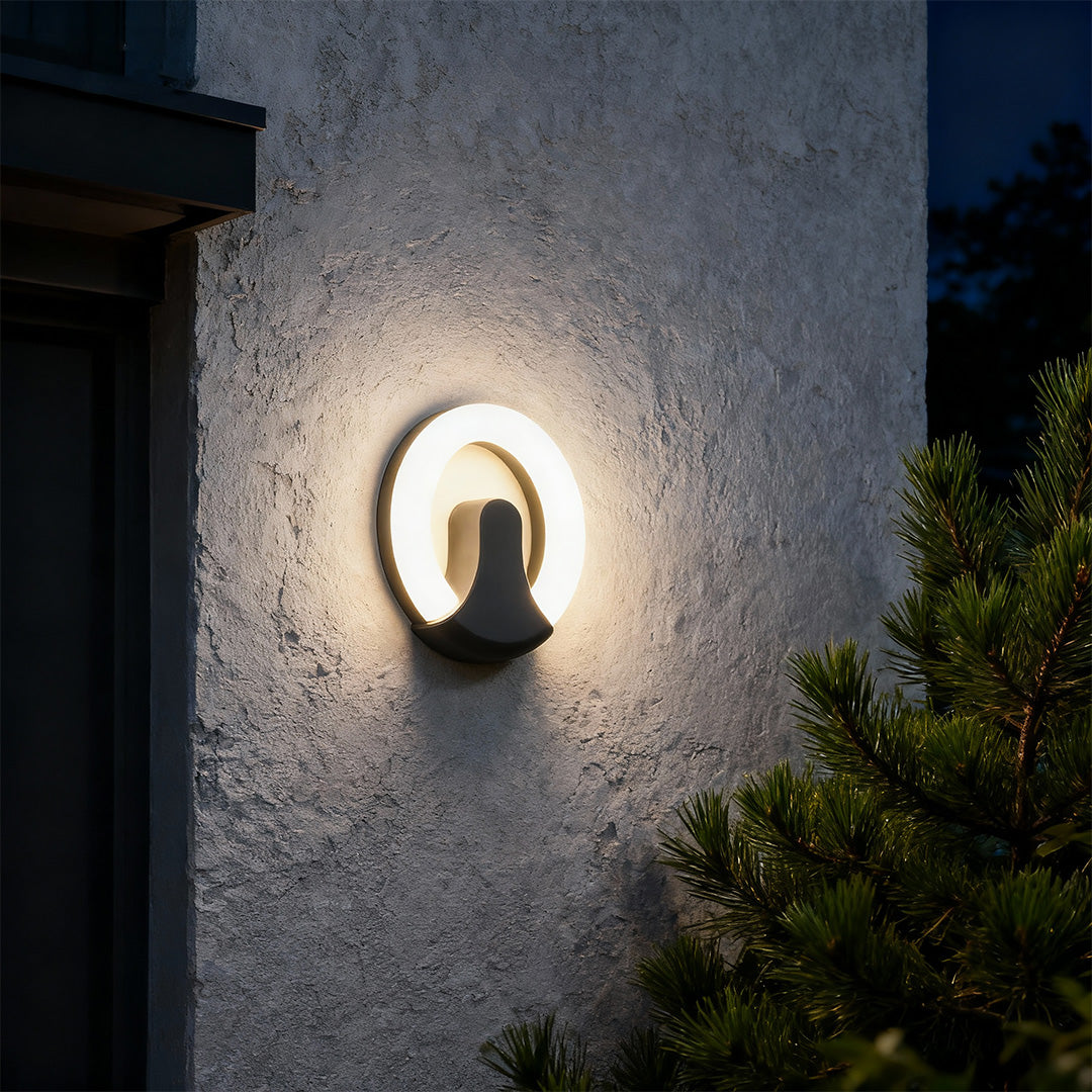 Architectural black wall sconce light featuring glass shade chandelier styling providing dramatic accent lighting at twilight entrance.