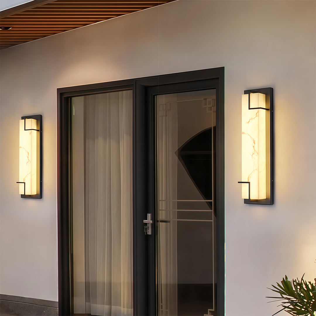 Architectural exterior wall lights black with glass shade chandelier styling flanking entrance door in minimalist contemporary setting.
