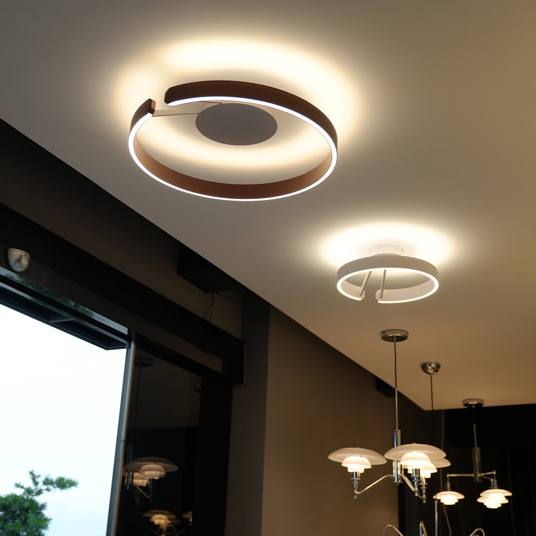 Architectural halo flush mount ceiling light with glass shade chandelier design in black creating dramatic ambient lighting in modern space.