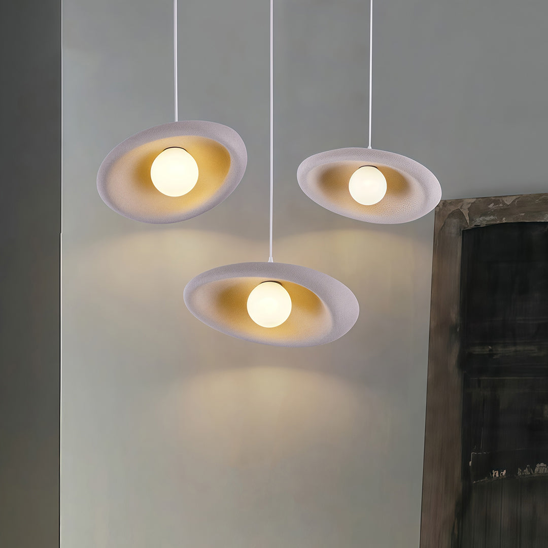 Architectural Japanese pendant lights with glass shade chandelier design in clustered white disc arrangement in modern interior.