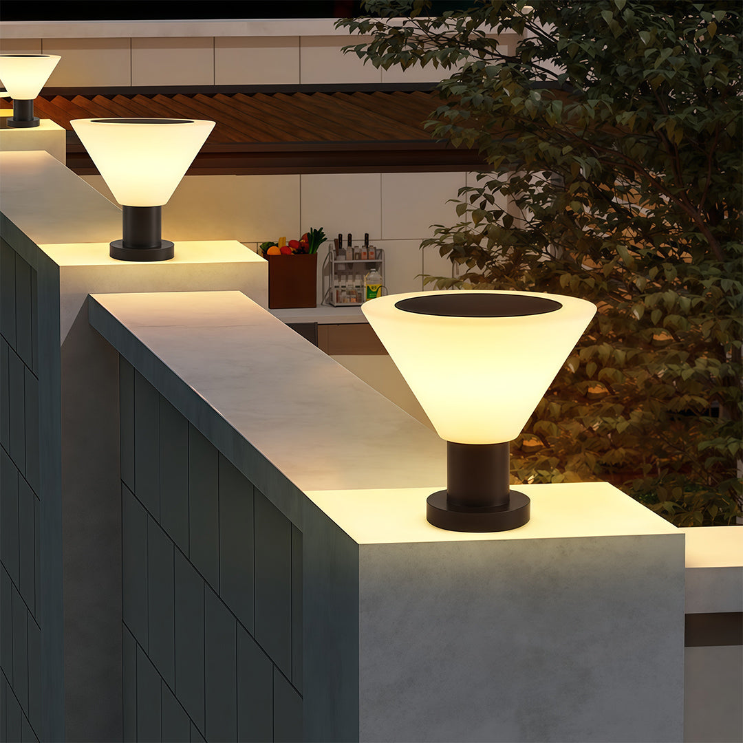 Architectural landscape pillar lighting with glass shade chandelier styling illuminating modern wall caps and steps at night.