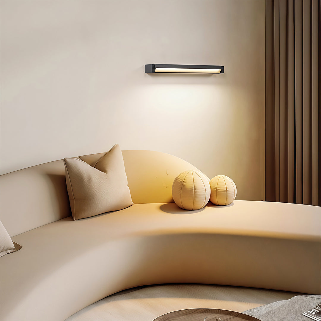 Architectural LED light bar for wall with glass shade chandelier styling creating warm downlighting on neutral wall surface.