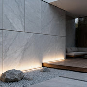 Architectural led strip lighting installed at ground level creating soft linear illumination along a modern concrete wall.