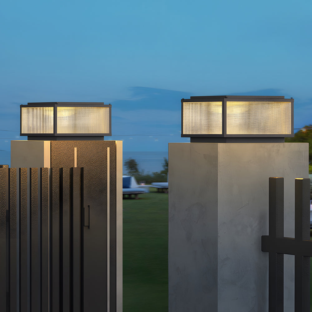 Architectural lighting fixtures mounted on contemporary concrete pillars illuminating modern outdoor space at twilight