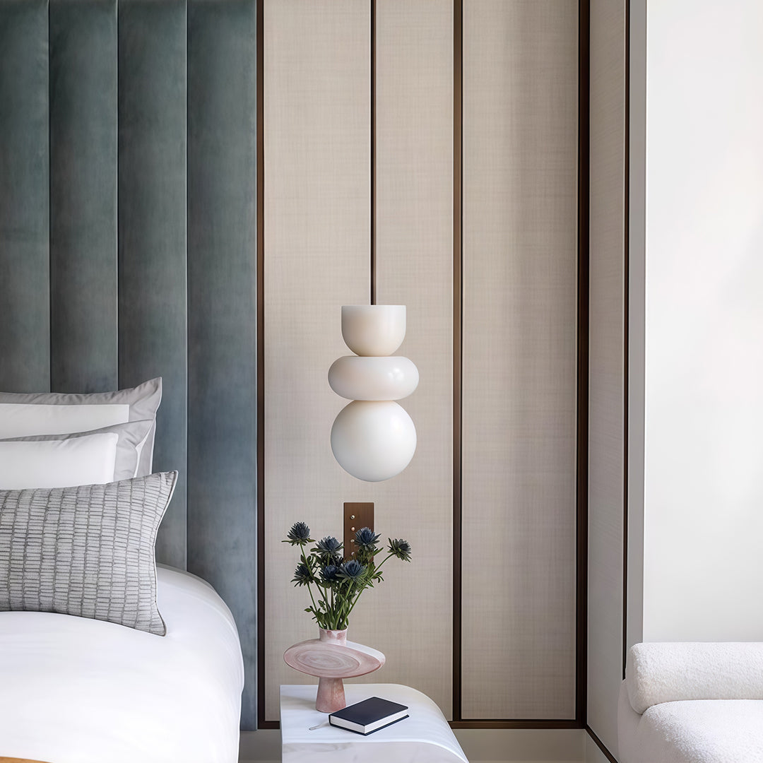 Architectural minimalist pendant light with glass shade chandelier styling providing warm accent lighting in minimalist dining space.