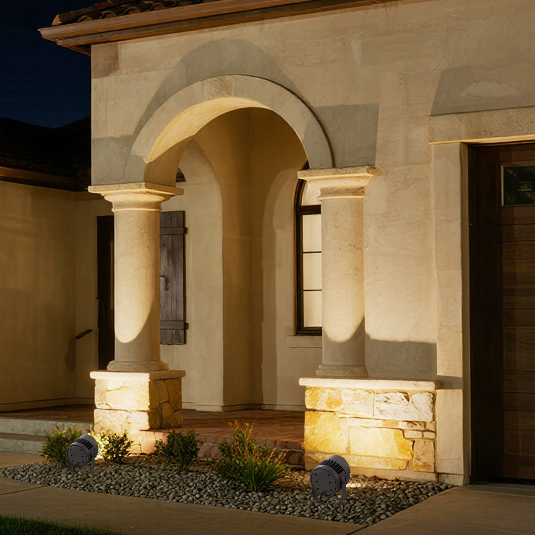 Architectural outdoor LED garden spotlights illuminating contemporary stone house with dramatic lighting