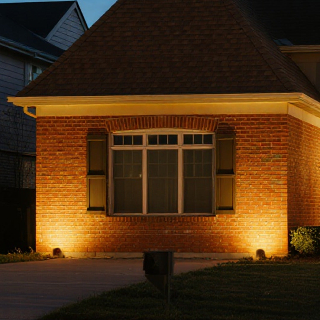 Architectural outdoor lighting LED spotlights creating warm accent lighting on brick building facade
