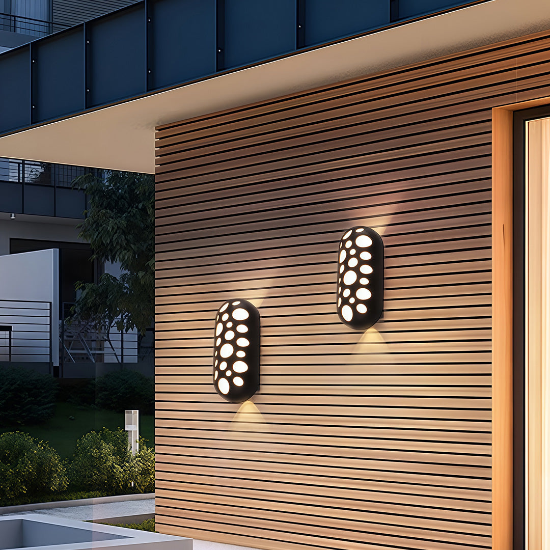 Architectural outdoor up down wall lights featuring glass shade chandelier styling on wood slat facade illuminating entry steps.