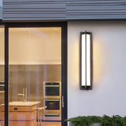 Architectural outdoor wall sconces black with glass shade chandelier styling illuminating contemporary home entrance at twilight.