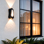 Architectural outside up down wall lights installed beside large windows, creating dramatic light patterns on the wall.
