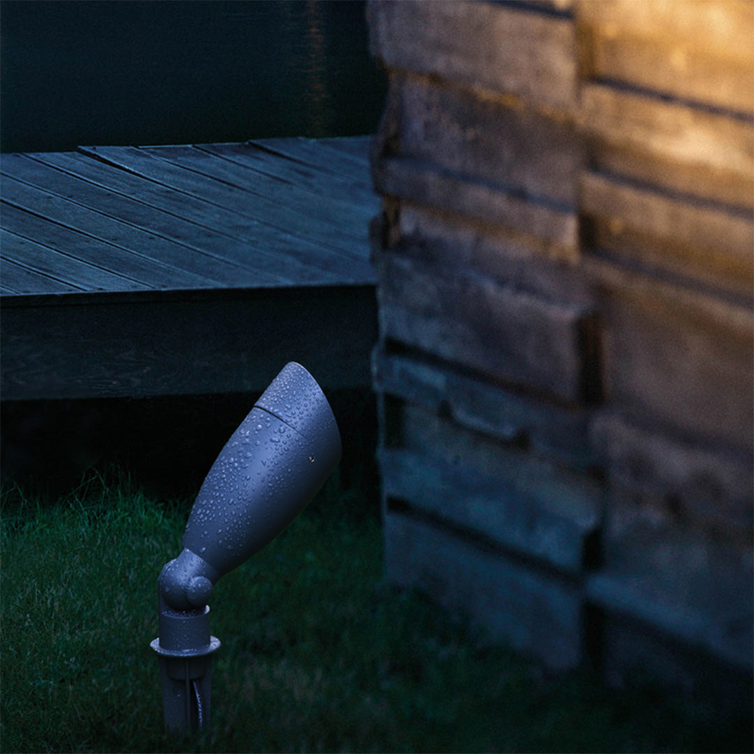 Architectural spotlight providing accent lighting on stone wall and water feature in contemporary design