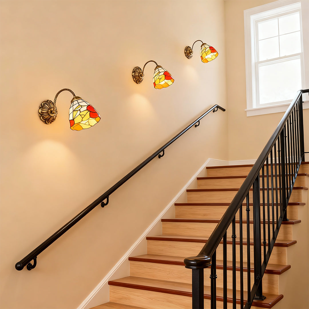 Architectural stained glass wall sconce lighting with glass shade chandelier styling providing ambient staircase illumination.