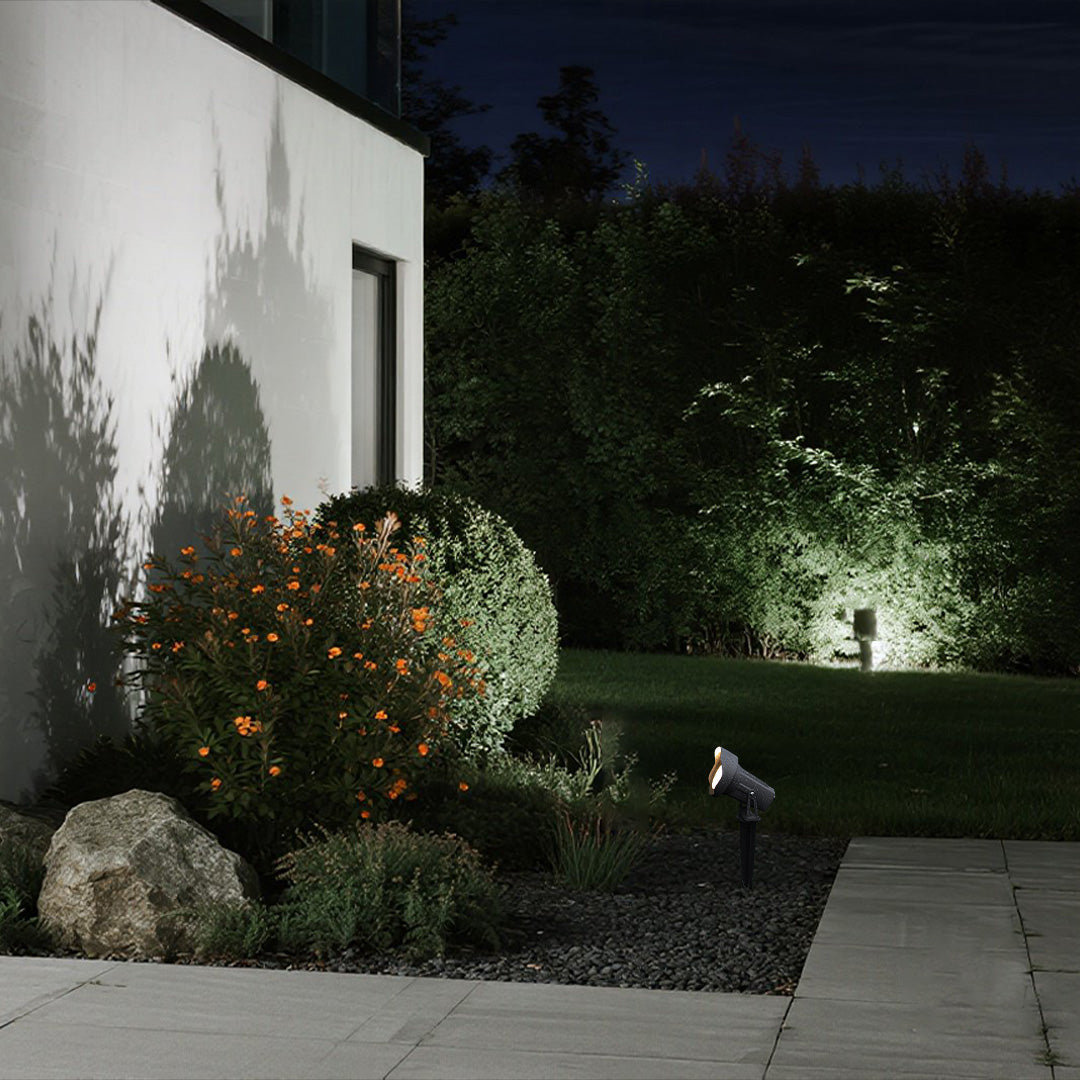 Architectural uplighting highlighting trees and modern building elements in contemporary landscape design