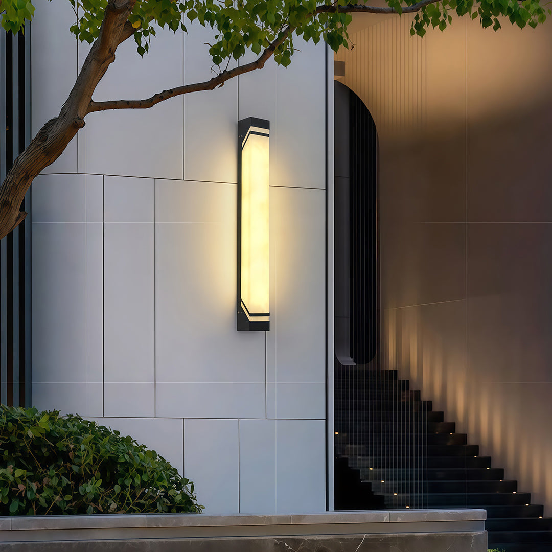 Architectural wall mounted exterior lights featuring glass shade chandelier design providing ambient lighting on modern gray exterior wall.