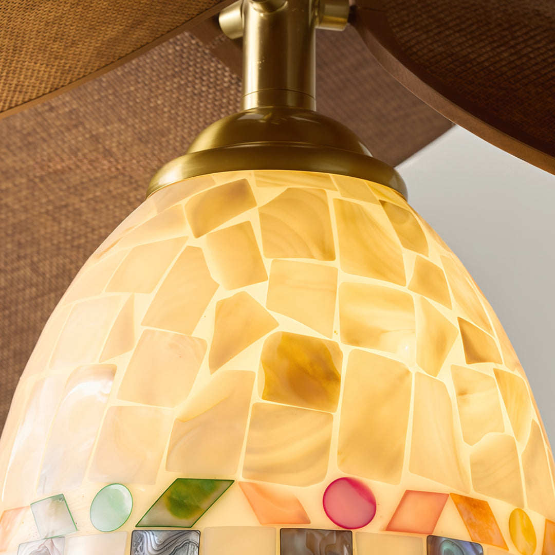 Art deco flush mount light fixture close-up showing handcrafted stained glass shade and warm illumination.