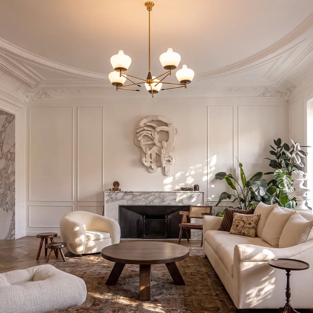 Art deco vintage chandelier illuminating an elegant living room with a fireplace, sofa, and round wood coffee table.