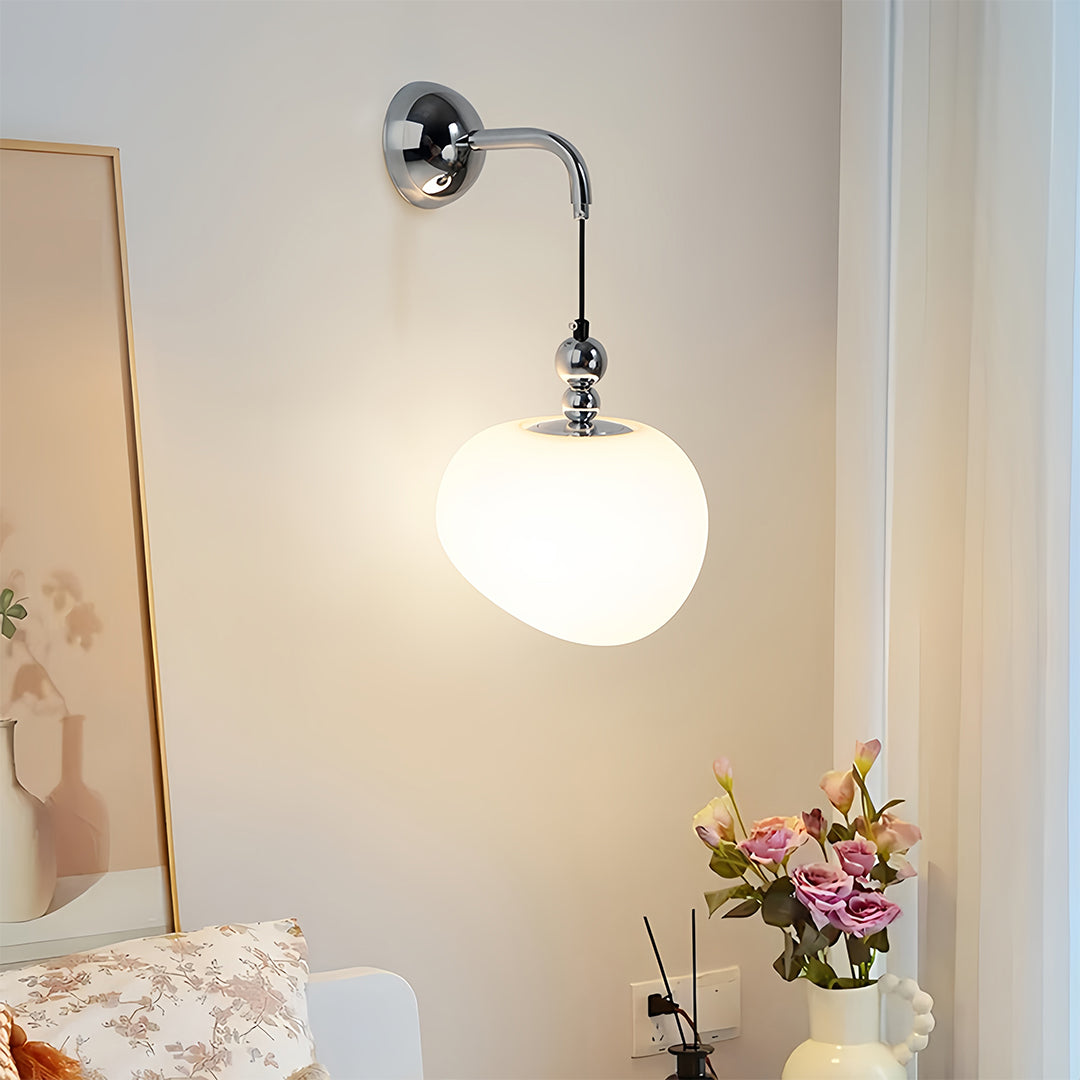 Art deco wall sconce lighting illuminating bathroom vanity with white globe shade creating soft ambient glow