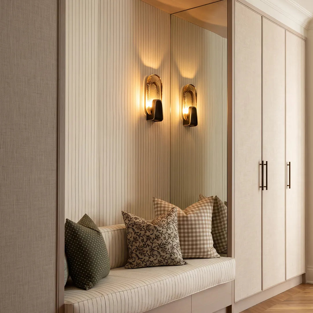 Art deco wall sconce lighting with oval glass shades mounted above a built-in bench.
