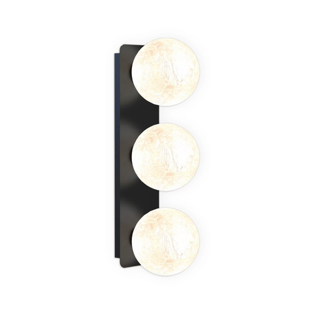 Three-light vertical art glass wall sconce with layered lighting effect.
