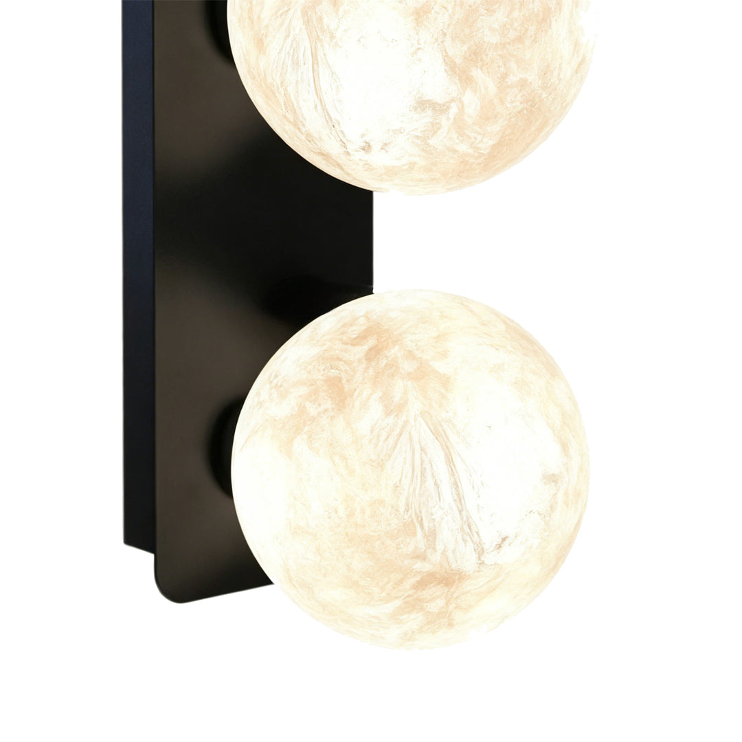 Double globe art glass wall sconce with black rectangular backplate.