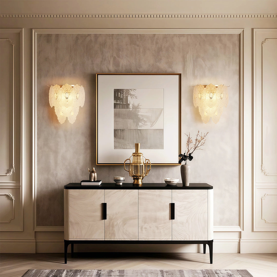 Art wall lights pair flanking mirror above console in sophisticated neutral-toned entryway
