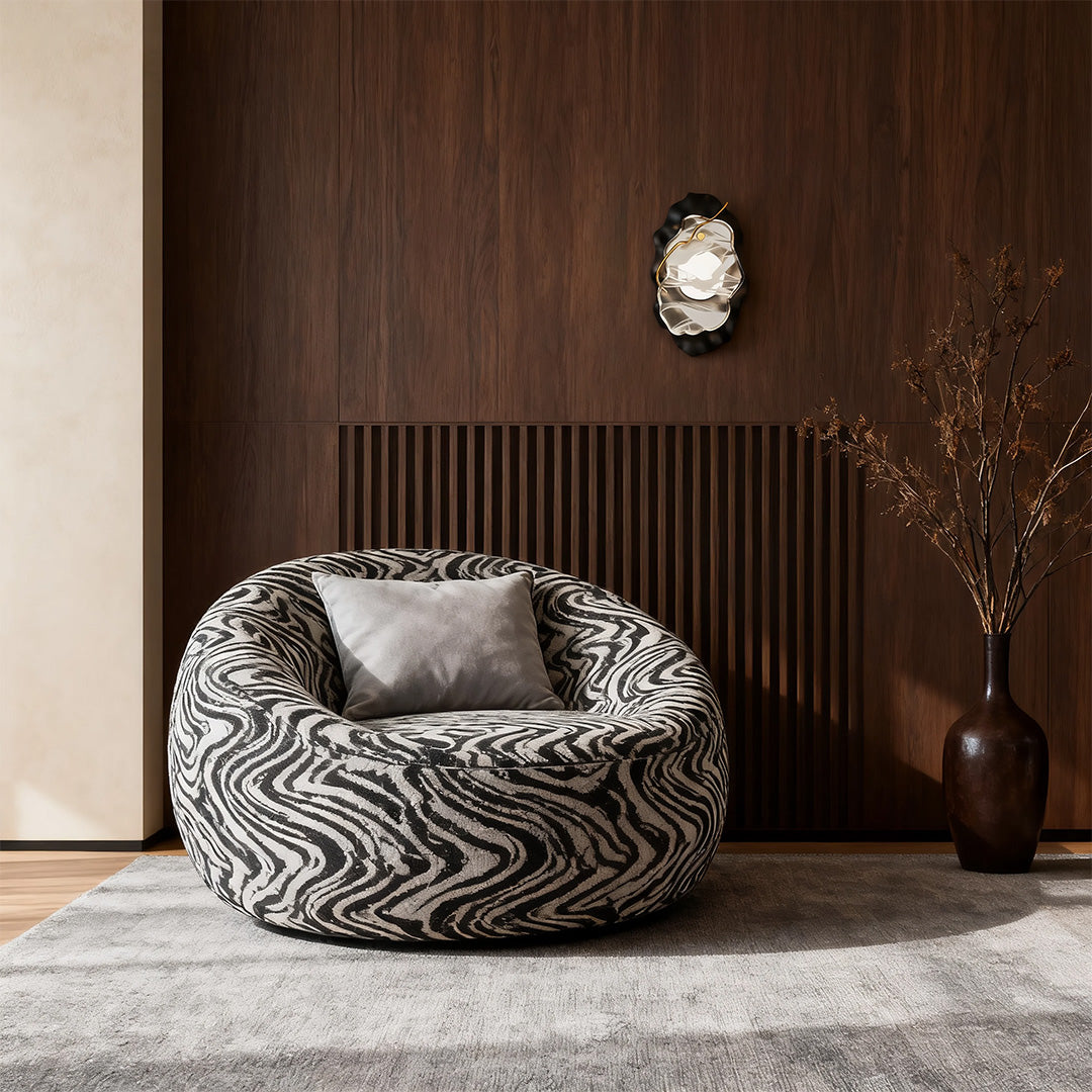 Artistic black wall light casting glow on dark wood wall near patterned lounge chair