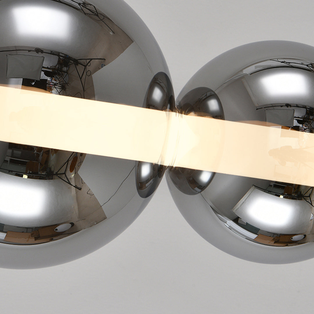 Artistic silver pendant light for kitchen island close-up showing reflective chrome spheres and warm LED lighting