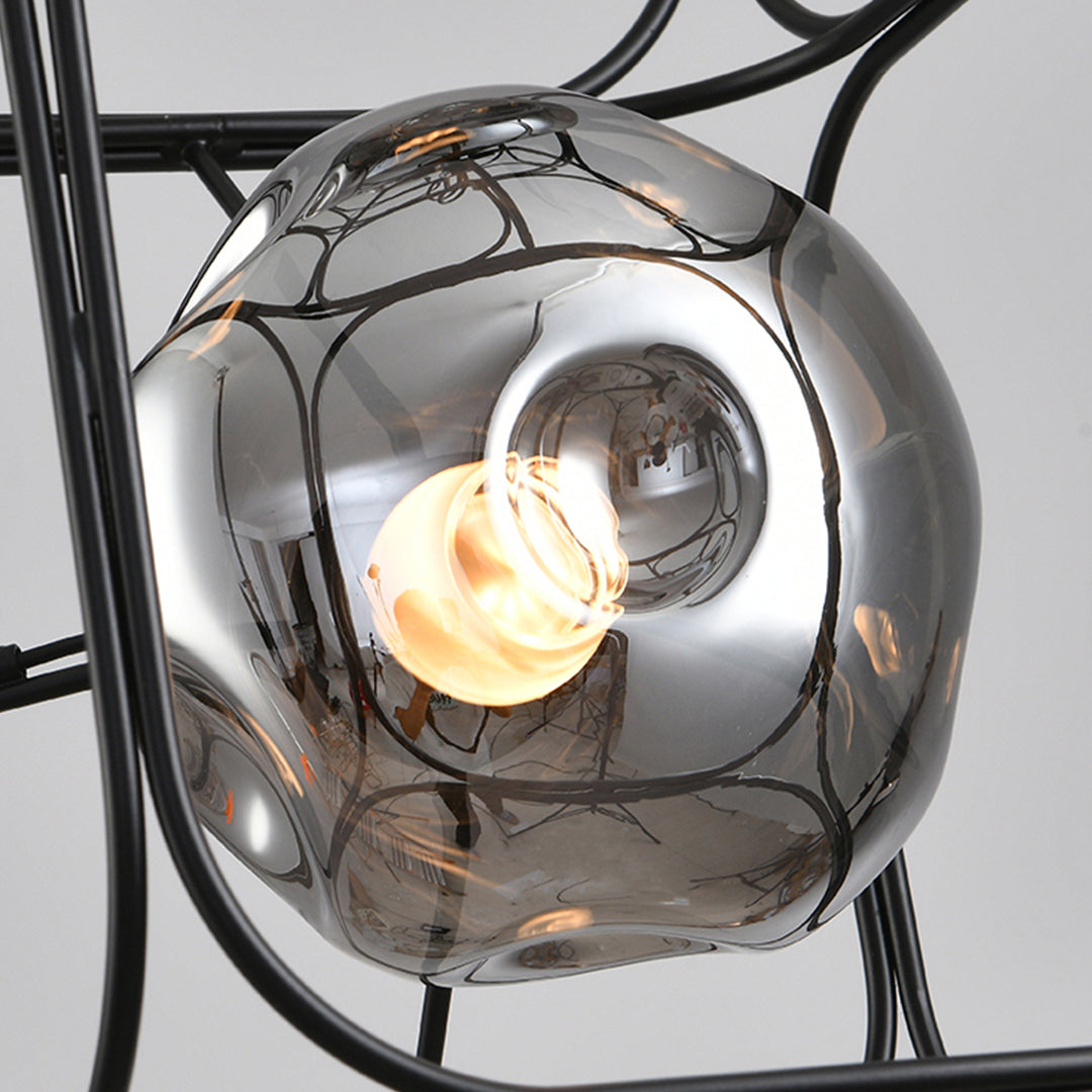 Artistic square cage chandelier installation showing detailed wire construction and atmospheric lighting effects