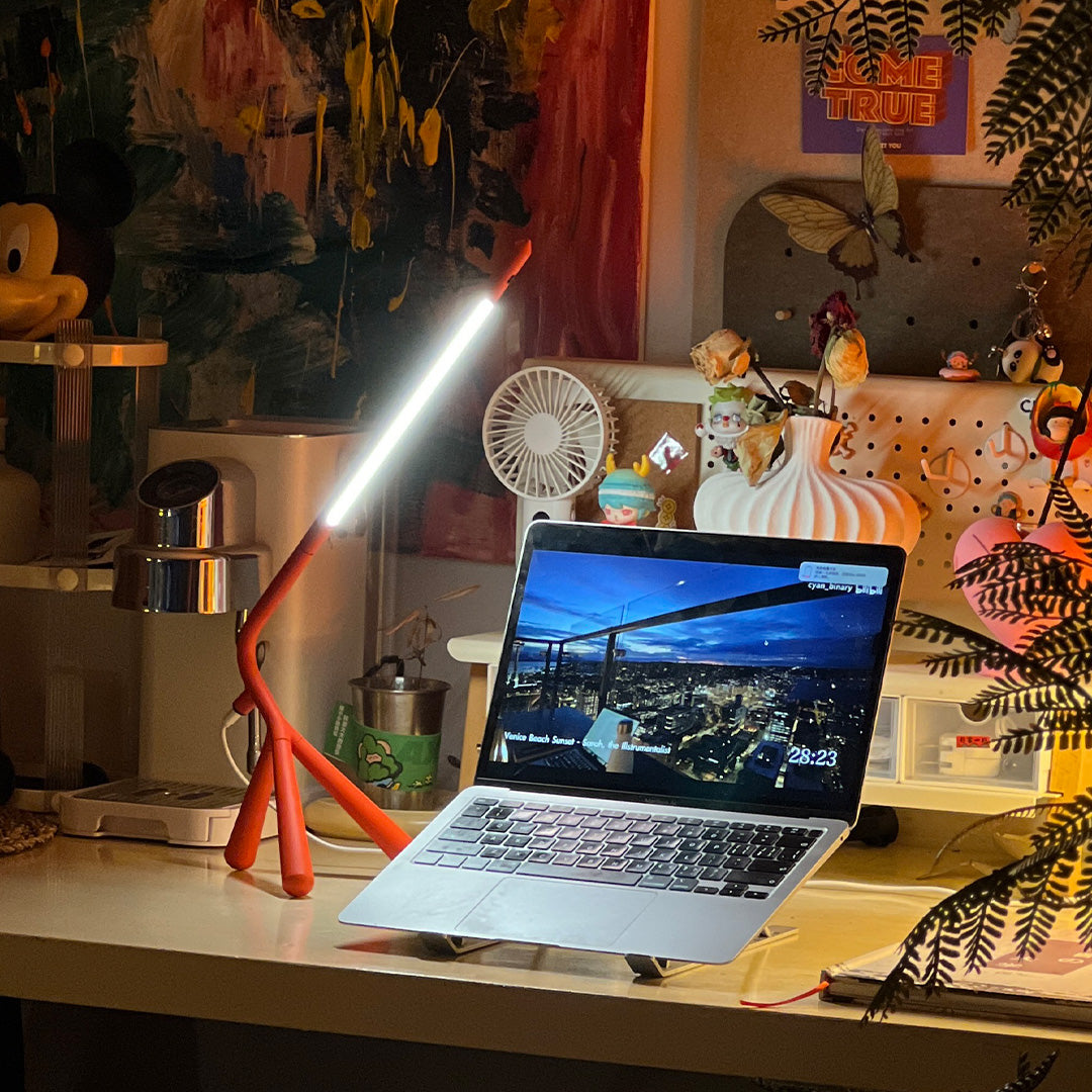 Artistic three legged table lamp with warm LED illumination enhancing creative studio environment