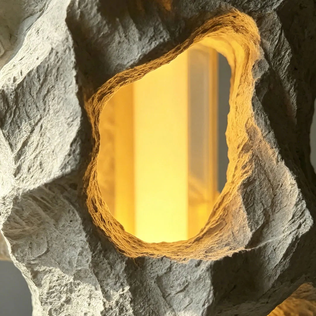 Close-up of artistic table lamps featuring a carved stone-like body with a warm glowing center.