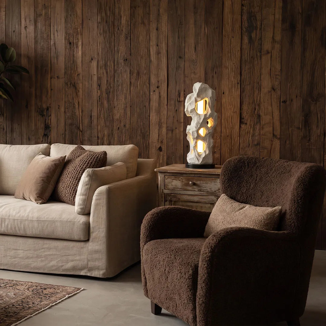 Artistic table lamps creating a sculptural lighting accent in a rustic living room corner.