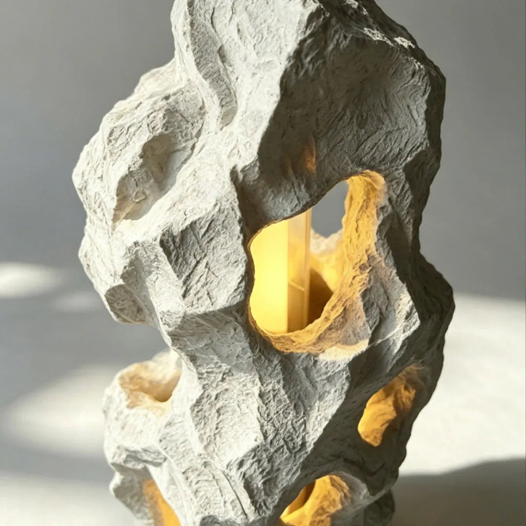 Close-up of artistic table lamps with an abstract sculptural form and multiple illuminated cutouts.