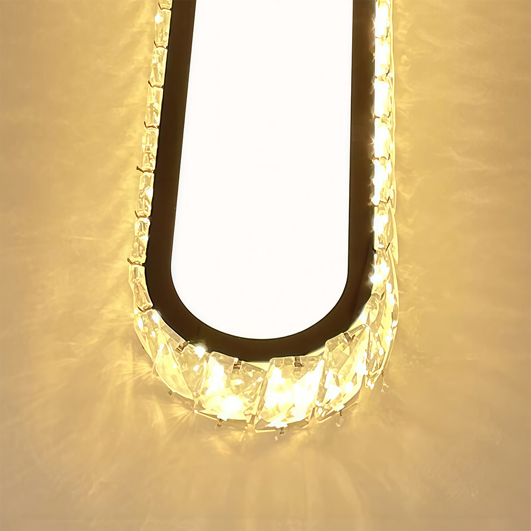 Artistic U-shaped detail view of LED flush mount light fixture with glass shade chandelier design and glowing crystal elements.