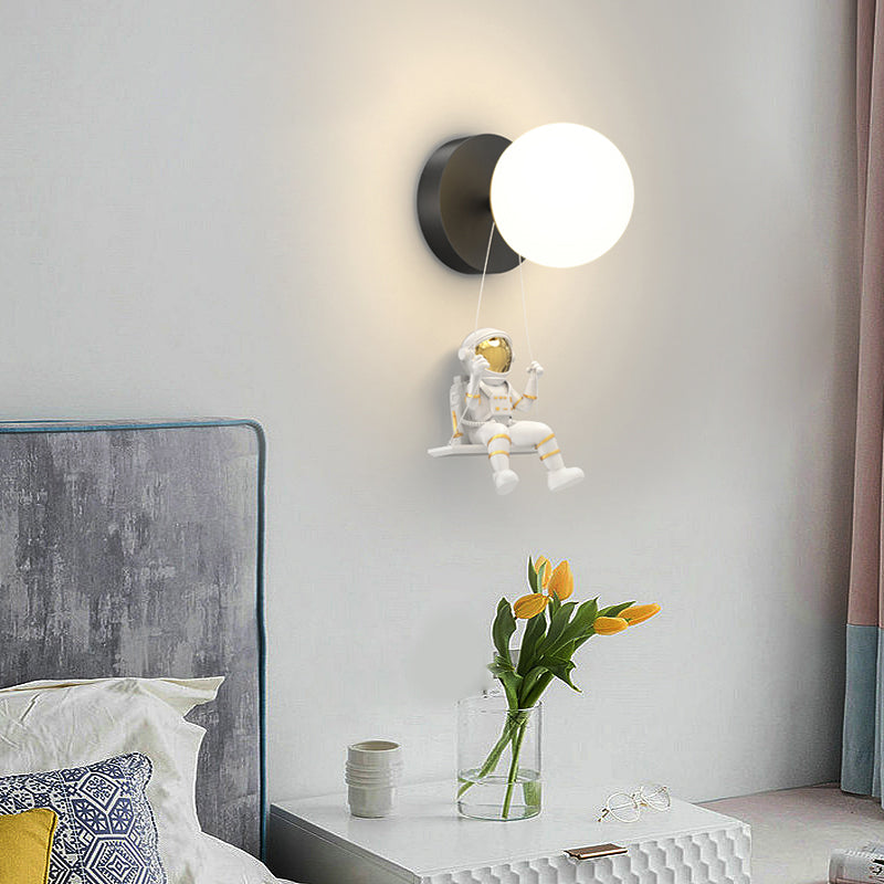 Astronaut wall light providing soft illumination in a stylish bedroom with a gray sofa.
