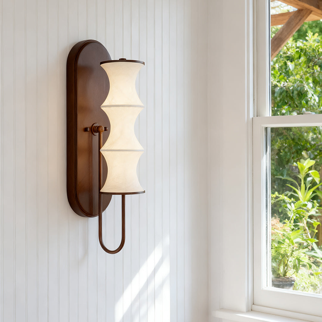 Modern triple cylindrical vintage French wall lights with white glass shades in a bright hallway