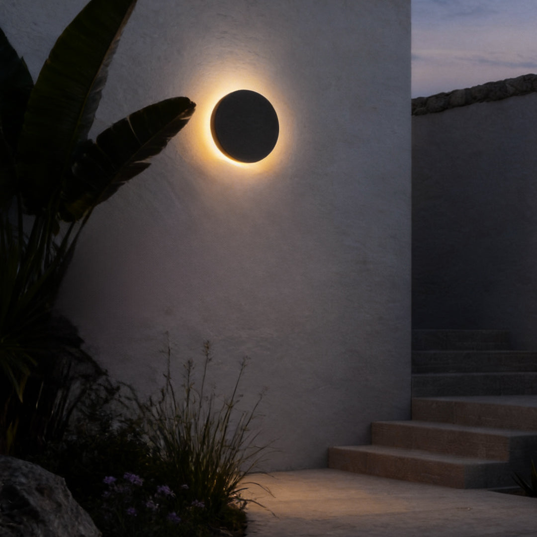 Round backlit wall light illuminating outdoor stairway