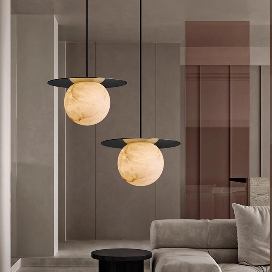 Ball pendant light with a white marble sphere, complementing a minimalist dining area.