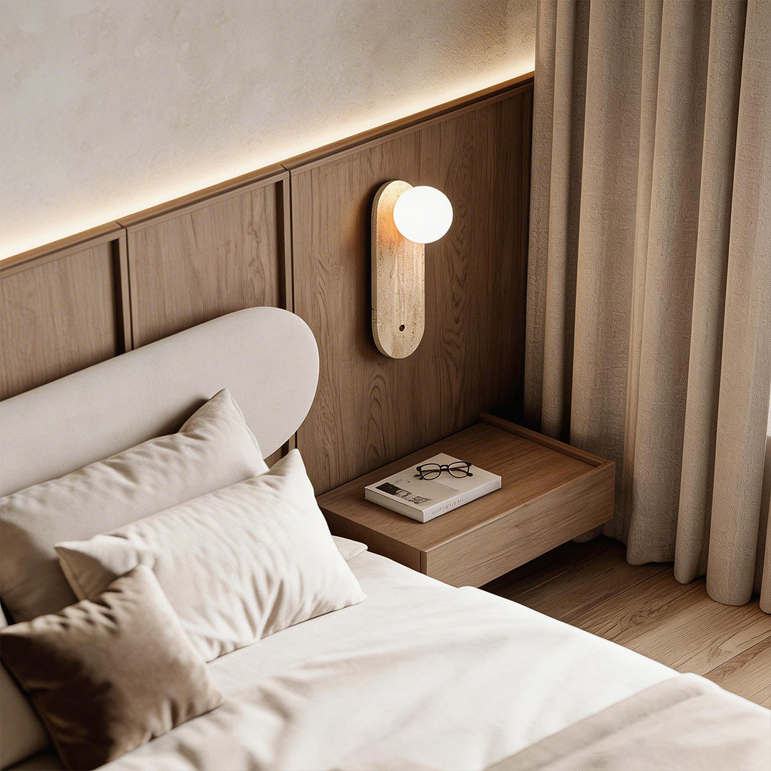 Ball wall lamp with a minimalist wooden design, providing soft illumination in a cozy bedroom.