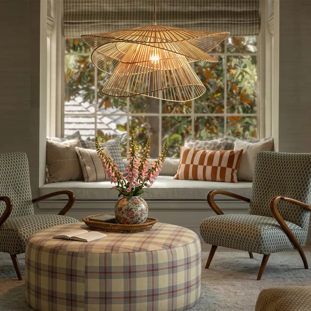 Bamboo pendant light fixture suspended above a round table in a cozy seating area by the window.