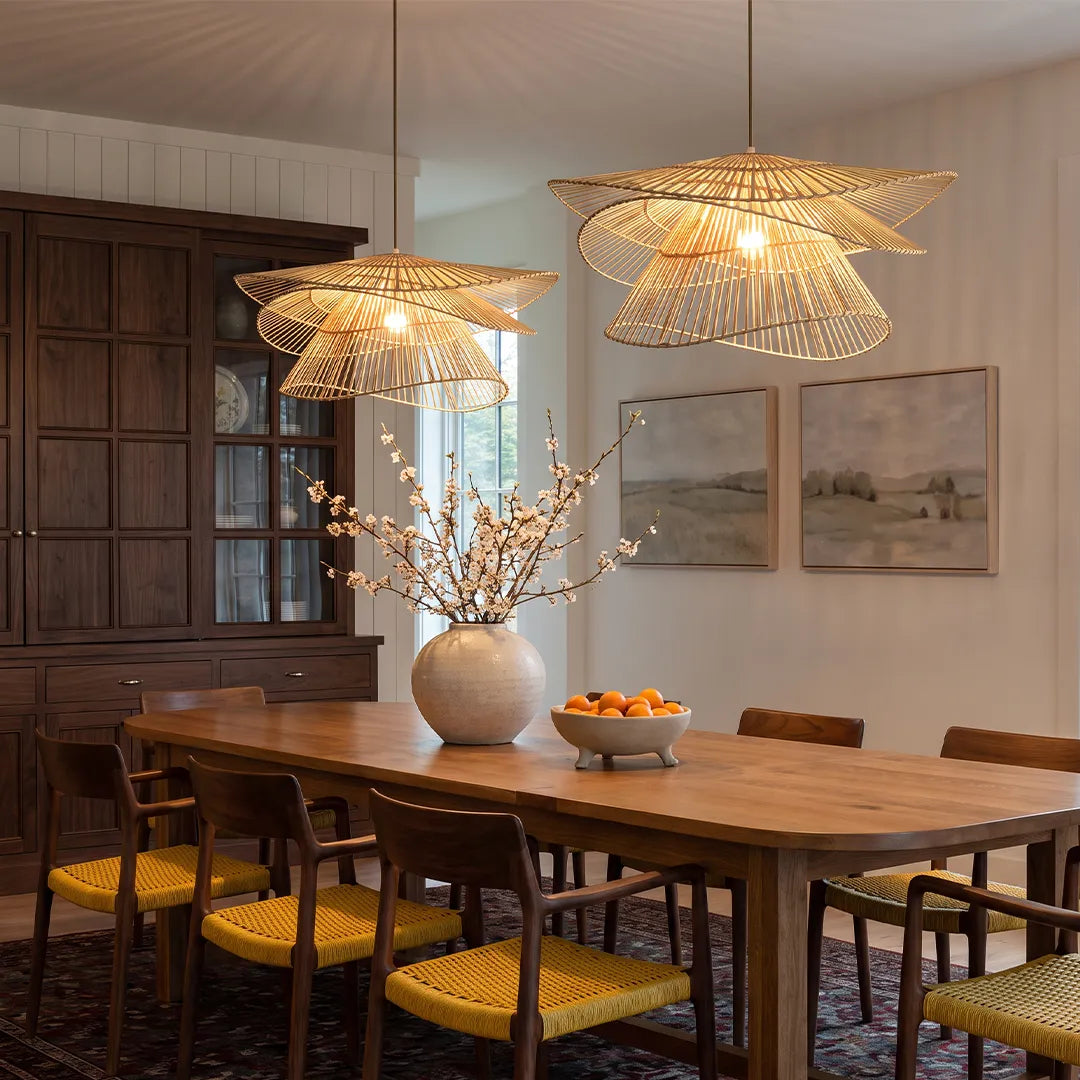 Bamboo pendant light fixtures hanging above a wooden dining table in a warm modern dining room.