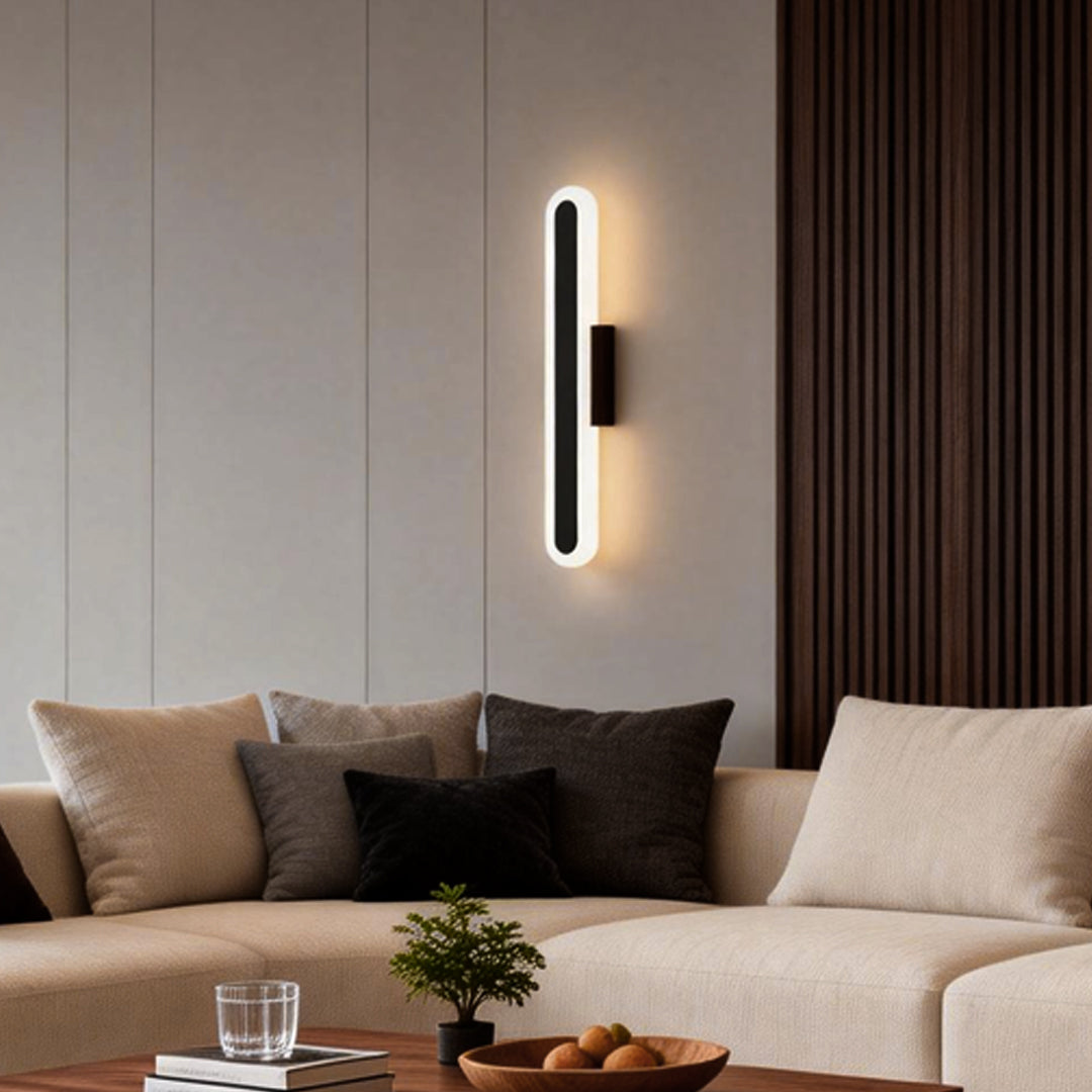Bar wall light with a sleek vertical design, illuminating a modern living room with beige sofas.