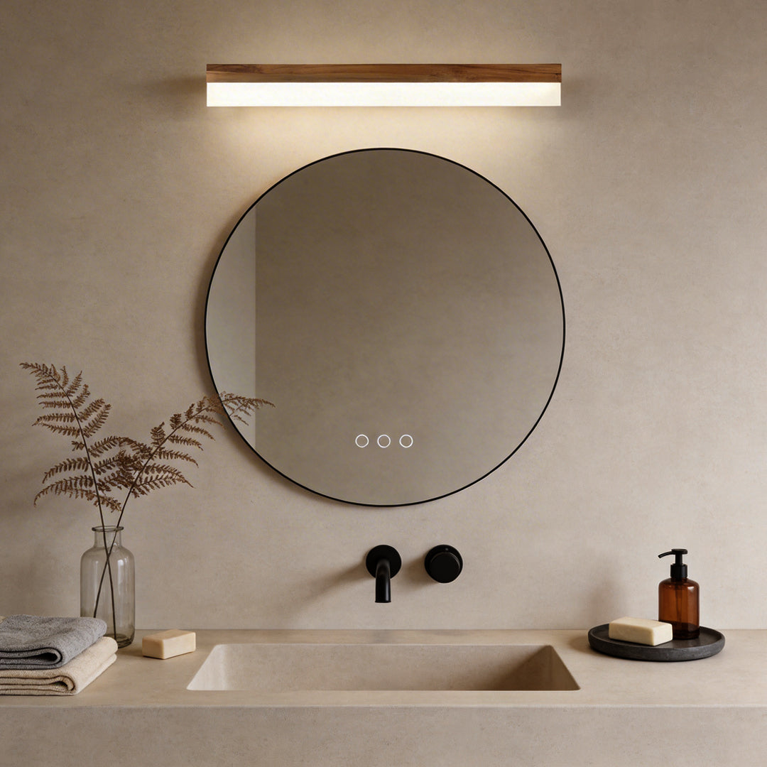 Bath bar vanity light with a sleek design, illuminating a modern round bathroom mirror.