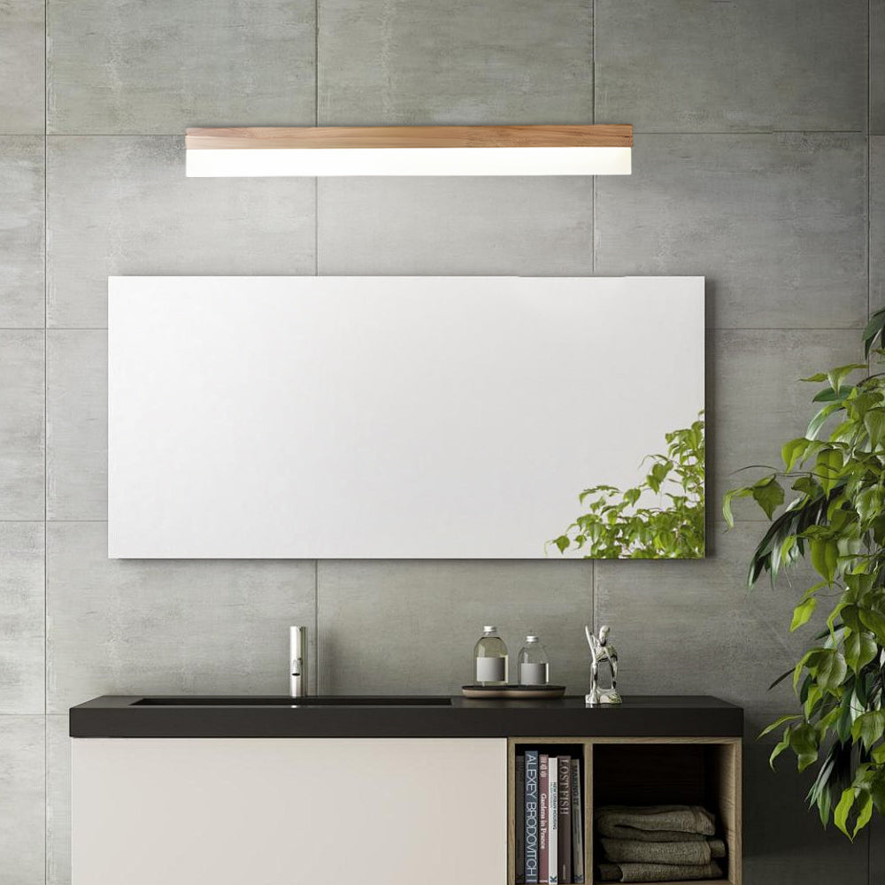 Bath bar vanity light with a sleek design, enhancing a bathroom with a round mirror and plants.