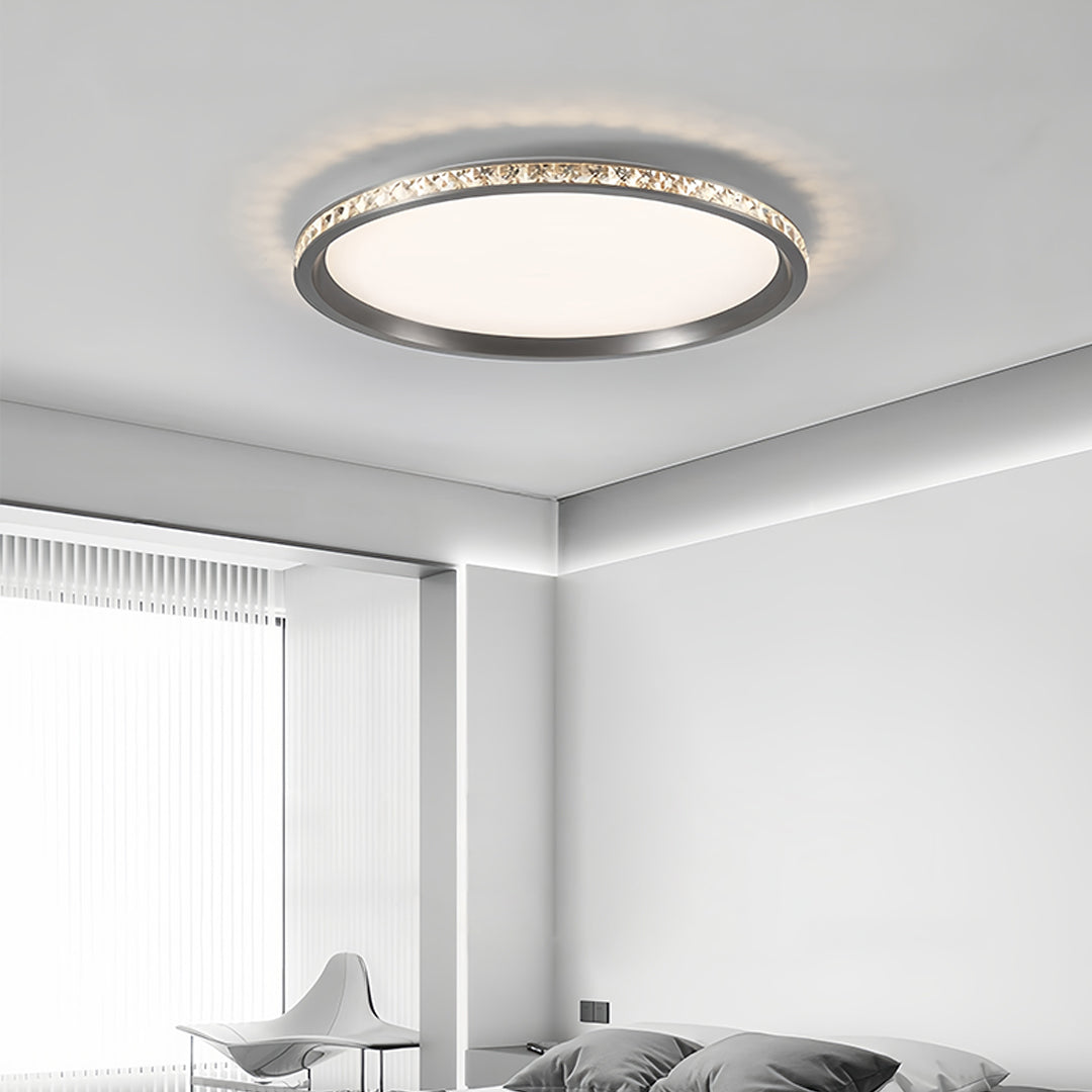 Crystal round flush mount LED light illuminating contemporary bathroom with clean white surfaces